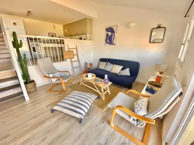 a living room with a blue couch and chairs at Terra Bella - mini Villa vue mer in Grosseto-Prugna