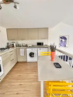 a kitchen with a table and yellow chairs at Terra Bella - mini Villa vue mer in Grosseto-Prugna