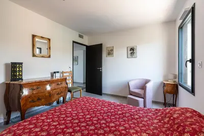 a bedroom with a bed with a red rug at Vita in Grosseto-Prugna
