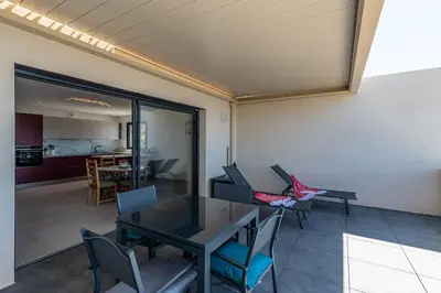 a dining room with a table and chairs and a kitchen at Vita in Grosseto-Prugna