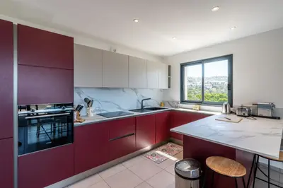 a kitchen with red cabinets and a large window at Vita in Grosseto-Prugna
