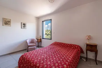 a bedroom with a red bed and a window at Vita in Grosseto-Prugna