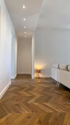 a living room with a couch and wooden floors at Ajaccio : Appartement de grand standing vue mer. in Ajaccio