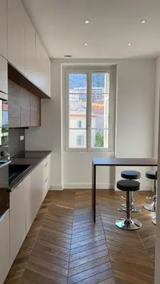 a kitchen with a table and two bar stools at Ajaccio : Appartement de grand standing vue mer. in Ajaccio