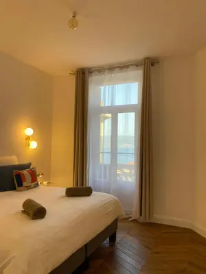 a bedroom with a bed and a large window at Ajaccio : Appartement de grand standing vue mer. in Ajaccio
