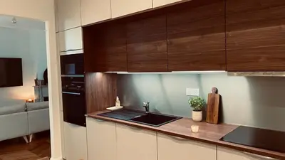 a kitchen with a sink and wooden cabinets at Ajaccio : Appartement de grand standing vue mer. in Ajaccio