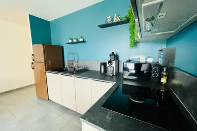 a kitchen with a refrigerator and a black counter top at Nice 60m With Terrace In Ajaccio in Ajaccio