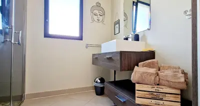 a bathroom with a sink and a mirror at Villa Bistinetti Rez de villa tout confort avec piscine in Penta-di-Casinca