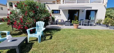 a yard with two blue chairs and a house at Villa Bistinetti Rez de villa tout confort avec piscine in Penta-di-Casinca