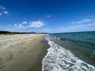 a beach with the ocean and a blue sky at Superbe appartement en résidence avec piscine proche plage in Linguizzetta