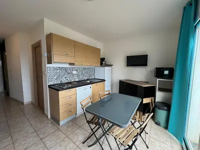 a kitchen with a table and chairs in a room at Superbe appartement en résidence avec piscine proche plage in Linguizzetta