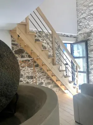 a staircase in a living room with a stone wall at U Vechju Fragnu in Vezzani