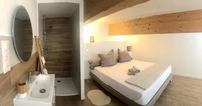 a bedroom with a bed and a bathroom with a sink at U Vechju Fragnu in Vezzani
