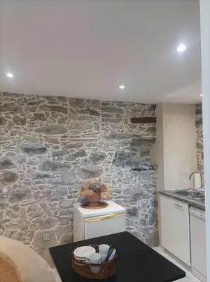 a kitchen with a stone wall and a table in a room at U Vechju Fragnu in Vezzani