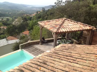 a swimming pool with a gazebo next to a house at Villa St Exupery in Oletta