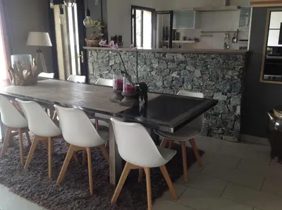 a dining room with a black table and white chairs at Villa St Exupery in Oletta