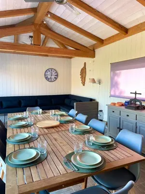a large wooden table with plates and glasses on it at Villa Alivu belle piscine chauffée in Bonifacio