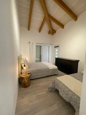 a bedroom with two beds and a window at Villa Alivu belle piscine chauffée in Bonifacio