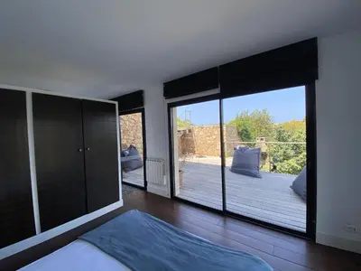 a bedroom with a large window with a view of a deck at Magnifique villa vue mer avec piscine in Coti-Chiavari