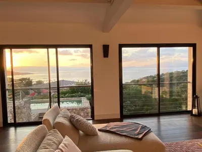 a living room with a couch and large windows at Magnifique villa vue mer avec piscine in Coti-Chiavari