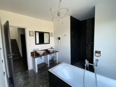 a bathroom with a tub and a sink and a mirror at Magnifique villa vue mer avec piscine in Coti-Chiavari