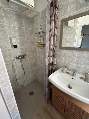 a bathroom with a white toilet and a sink at Rez de villa pour 2 personnes près de Santa Giulia in Sotta