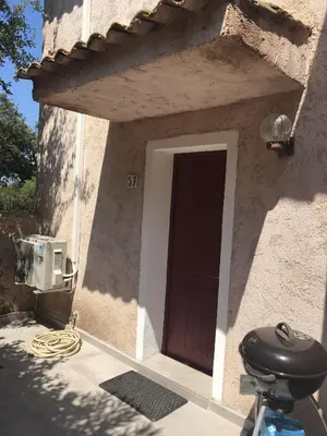 a door to a house with a yard at Duplex vue mer EXCEPTIONNELLE en Corse du sud proche plage - le 180Corse in Conca