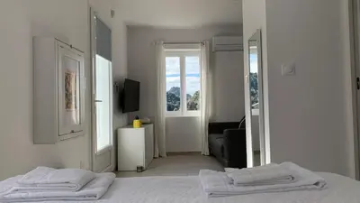a white bedroom with two white towels on a bed at Résidence Casa Olea - Studio - T2 - T3 in Cauro
