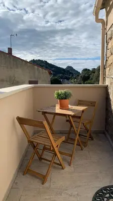 a wooden table and two chairs on a balcony at Résidence Casa Olea - Studio - T2 - T3 in Cauro