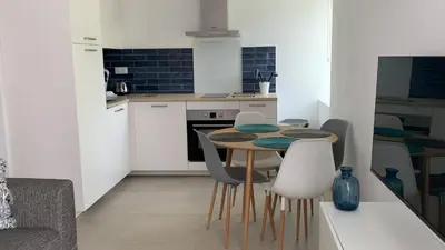 a kitchen with a table and chairs in a room at Résidence Casa Olea - Studio - T2 - T3 in Cauro