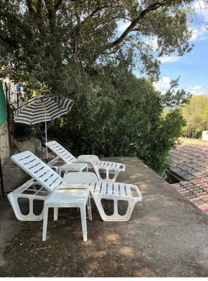 a group of lawn chairs and an umbrella at Mini Villa St-Lucie Porto-Vecchio vue mer 5mnplage in Zonza