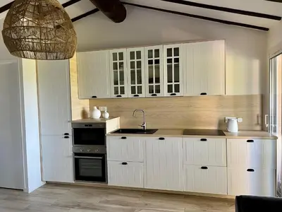 a kitchen with white cabinets and a sink at Mini Villa St-Lucie Porto-Vecchio vue mer 5mnplage in Zonza