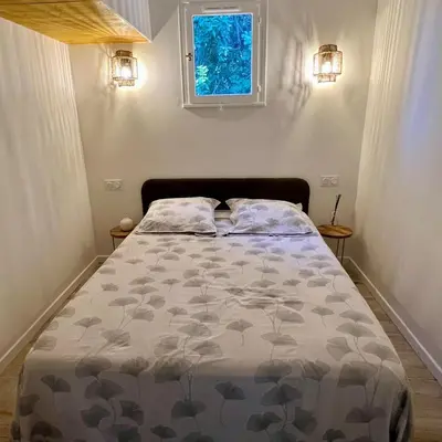 a bed in a small room with a window at Mini Villa St-Lucie Porto-Vecchio vue mer 5mnplage in Zonza