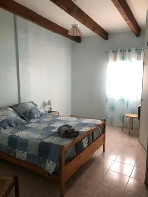 a bedroom with a bed in a room with a window at chez marie jo Chez marie jo in Cozzano