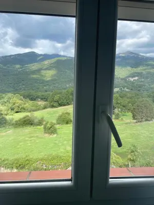 a window with a view of a green field at chez marie jo Chez marie jo in Cozzano