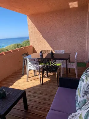 a patio with a table and chairs on a balcony at Appartement « Marinella » splendide vue mer aux Sanguinaires in Ajaccio