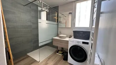 a bathroom with a washing machine and a shower at Appartement « Marinella » splendide vue mer aux Sanguinaires in Ajaccio