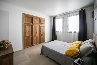 a bedroom with a bed and a wooden door at SARTENE t3 CALME ENSOLEILLÉ PARKING PRIVÉ in Sartène