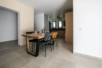 a kitchen and dining room with a wooden table and chairs at SARTENE t3 CALME ENSOLEILLÉ PARKING PRIVÉ in Sartène
