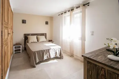 a bedroom with a bed and a large window at SARTENE t3 CALME ENSOLEILLÉ PARKING PRIVÉ in Sartène