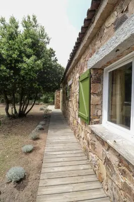 a building with a wooden walkway next to a window at Maison 1 in Porto-Vecchio