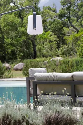 a bench sitting next to a pool with a lamp at Maison 1 in Porto-Vecchio