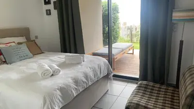 a bedroom with a bed and a balcony with a bench at Duplex Horizon vue mer in Pietrosella