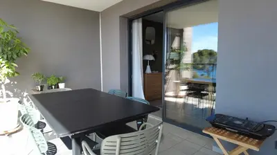 a black table and chairs in a room with a balcony at Duplex Horizon vue mer in Pietrosella