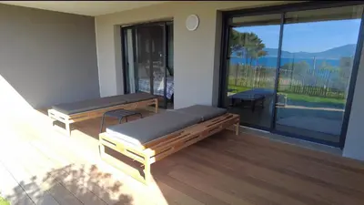 a room with two benches and a balcony with a view at Duplex Horizon vue mer in Pietrosella