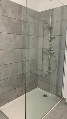 a shower with a glass door in a bathroom at Duplex Horizon vue mer in Pietrosella