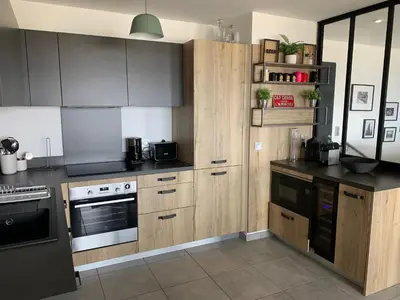a kitchen with wooden cabinets and a stove at Duplex Horizon vue mer in Pietrosella