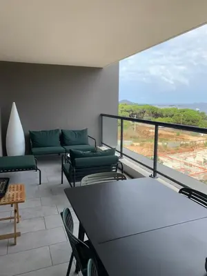 a room with chairs and a table and a large window at Duplex Horizon vue mer in Pietrosella