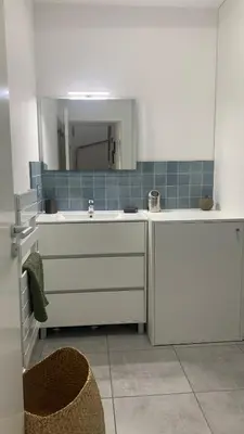 a white kitchen with a sink and a mirror at Duplex Horizon vue mer in Pietrosella