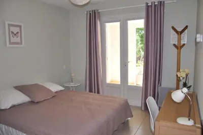 a bedroom with a bed and a table and a window at Appartement charmant en Corse avec terrasse au calme in Santa-Lucia-di-Moriani